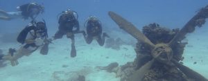 Divers hover over a wrecked Emily aircraft from the Battle of Saipan.